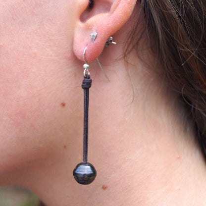 Femme portant une boucle d'oreille en cuir et perle de Tahiti